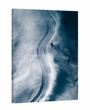Freeride skiing. Two skiers descending a snowy mountain, kicking up powder snow and leaving tracks
