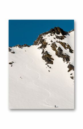 High angle view of a snowy mountainside where a splitboarder has descended on his splitboard