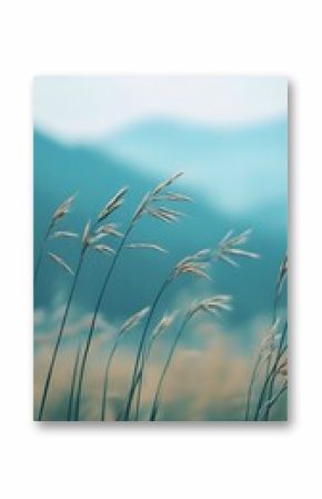 A serene view of tall grass swaying gently in the breeze, set against a soft-focus mountain backdrop, conveying tranquility.