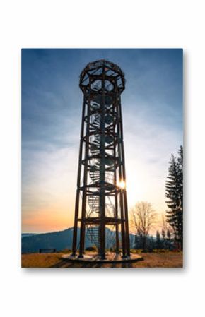 Svetly vrch Lookout Tower stands tall in Albrechtice, offering breathtaking views of the surrounding mountains at sunset. Visitors can enjoy a tranquil atmosphere and stunning scenery.