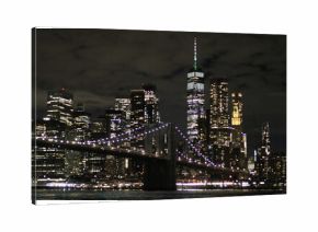 Nocny widok na Brooklyn Bridge i panoramę Manhattanu z DUMBO. Oświetlony most, refleksy w wodzie i tętniące życiem miasto tworzą niezapomniany klimat Nowego Jorku.