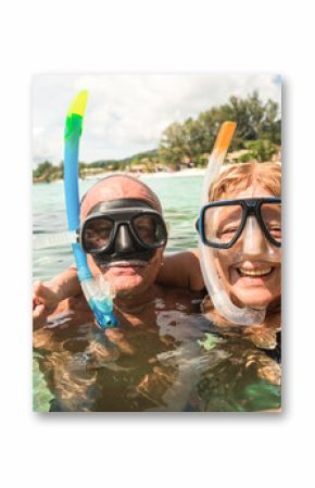 Senior happy couple taking selfie in tropical sea excursion with water camera - Boat trip snorkeling in exotic scenarios - Active retired elderly and fun concept around the world - Warm bright filter
