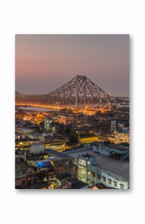 Beautiful view of Kolkata city with a Howrah bridge on the river Hooghly at twilight.