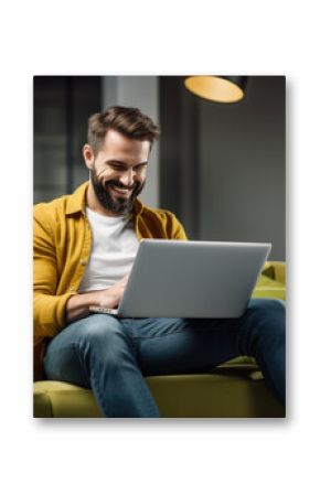 A man in a casual outfit works on a laptop in his office