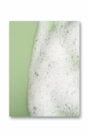 White fluffy foam on green background, top view. Space for text