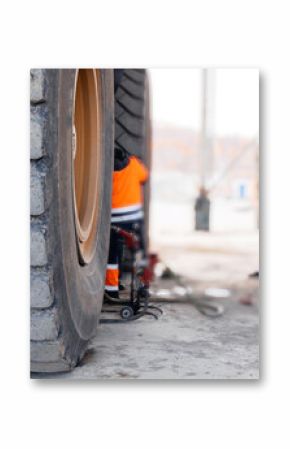 Replacing tires on wheels of mining dump car in garage. Maintenance fix service of industry truck