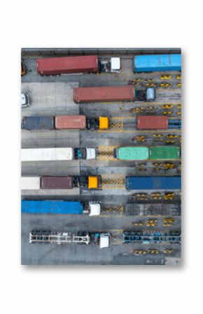 Aerial view semi trailer trucks stand on the parking lot and wait for loading and unloading cargo container at container terminal port, Global business logistic transportation semi trailer trucks.