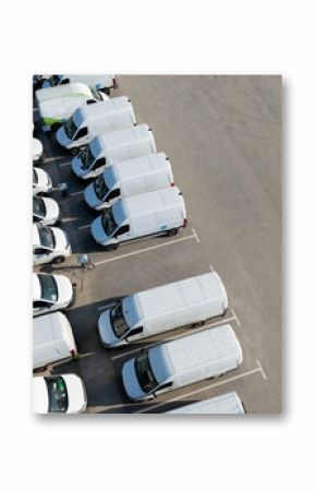 Rows of white electric delivery vans at charging stations for electric vehicles.