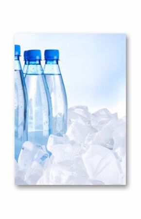 Cold water bottles resting on ice cubes on light blue background