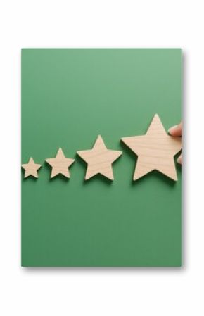 Rating concept with hand placing wooden star to increase satisfaction level on green background