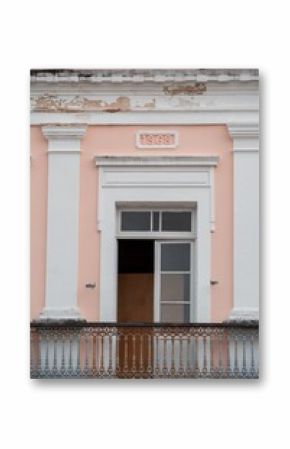 Historic building facade with ornate balcony and '1868' date in pastel colors.