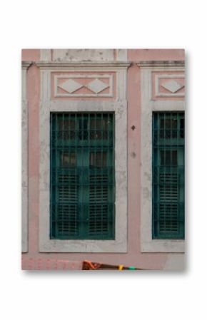 Vintage architecture with green shutters on a pink wall