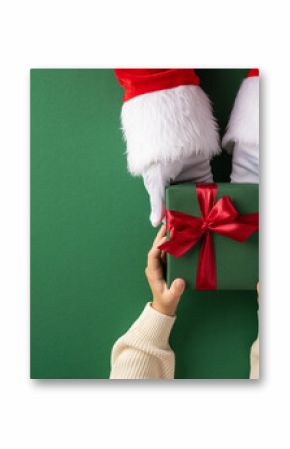 Santa Claus presents a festive green gift box to a child with a joyful holiday spirit