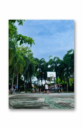 Blurred Basketball Court with Group of People Playing Game Outdoors.