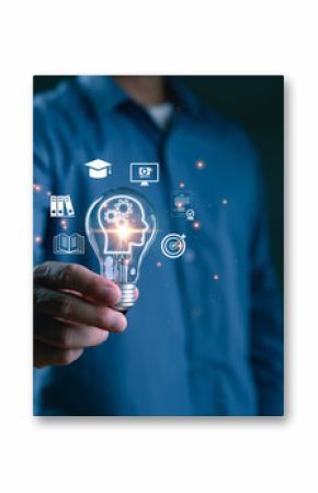 Businessman holding light bulb with learning and education icons. Concept of knowledge development, digital education, innovative learning, brain training, online course and future skills.