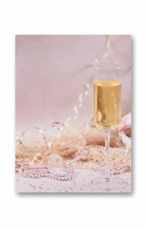 Masquerade ball holiday background. Glass of white champagne, Venetian carnival mask and feathers on light pink background