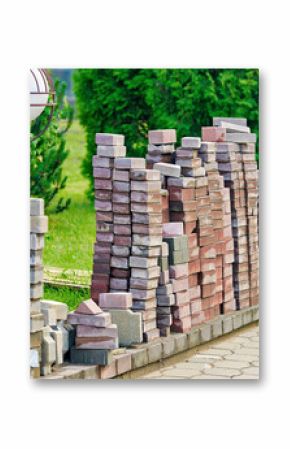 Paving stone repair and replacement with stacked slabs on sidewalk ready to restore and renovate damaged pedestrian pathway surface. Sidewalk repair process with paving slabs stacked in piles