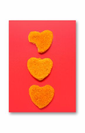 Tasty nuggets in shape of heart on red background. Valentine's Day celebration