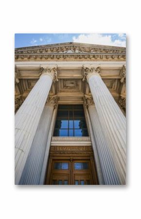 A majestic building features towering pillars and an impressive entrance, symbolizing justice and power.