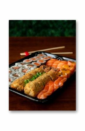 Delicious sushi assortment on a black tray.