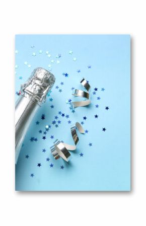 Bottle of champagne and confetti on blue background. New Year celebration