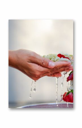 Hand of young woman pour water and flowers on the hands. older women and happy for the songkran festival. concept gives blessing in Songkran day Thailand