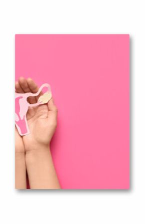 Female hands with paper uterus on pink background, closeup