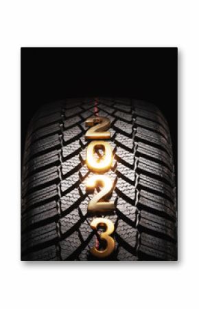 Happy new year 2023 and winter Car tire for snow isolated on black background. New automobile tyre for snowy road.