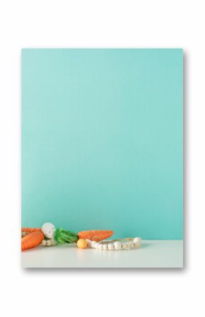 Easter display setup: Side view photo of a counter featuring a vase with pussy willow, a ceramic bunny figure, carrots for Easter bunny, assorted eggs, and beads on a pastel blue wall background