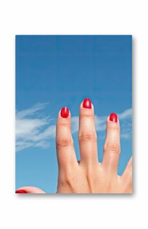 A woman s hand adorned with red painted nails and a black ring on the pinky finger reaches out into the vast expanse of a blue sky creating a beautiful copy space image 200 characters