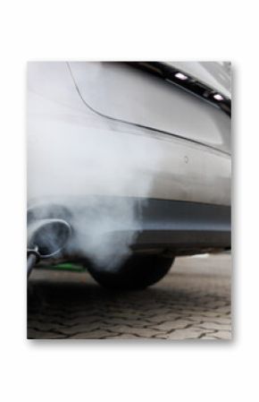 Car exhaust pipe emits dense smoke during emission test on city pavement. Pollution control device measures harmful gases. Service car center garage workshop.  Automobile repair check up diagnosis