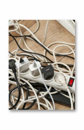 Extension power boards overloaded with plugs on wooden floor, closeup