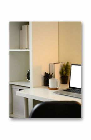 Minimalist home office setup with blank laptop screen, coffee mug, and organized shelf