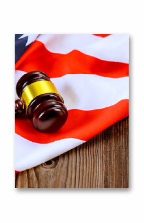 Justice wooden gavel rests on draped American flag, symbolizing justice, legal proceedings in US courtroom
