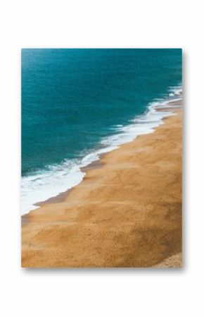 Aerial view of a deserted beach with turquoise waves.