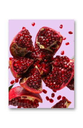 Flying fresh pomegranates with seeds on lilac background
