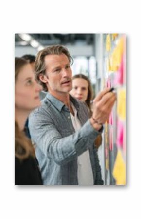 In a bright hightech office a product manager guides a daily scrum meeting updating user stories and next steps on an interactive digital task board.