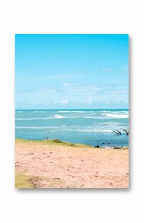 Serene beach scene with gentle waves, clear blue sky, and sandy shore
