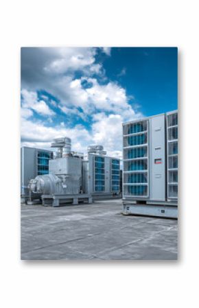 Air conditioning units on modern building rooftop under cloudy blue sky. Industrial cooling systems feature ventilation, compressor technology, essential for climate control in urban, commercial