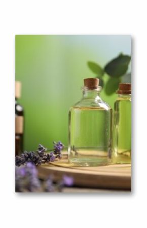 Bottles of essential oils and different plants on table outdoors, closeup