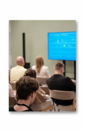 Audience listening to speaker presenting in a contemporary seminar setting, fostering engagement.