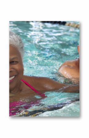 Joyful senior black couple woman and man swim in clear water with a radiant smile