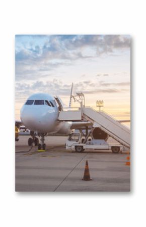 Commercial Airplane On Tarmac At Sunset With Mobile Stairs And Service Vehicles
