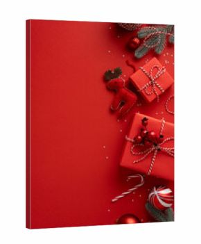 Vertical composition featuring gift boxes wrapped in twine, red ornaments, a plush reindeer, candy canes, and pine sprigs on a bold red backdrop