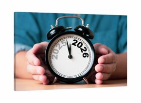Businessman holding an alarm clock showing the transition from 2025 to 2026 symbolizing time change new year planning future goals strategy and preparation for business and personal development