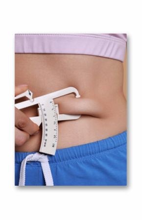 Woman measuring body fat with caliper on beige background, closeup