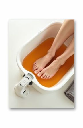 Woman on ionic detox foot bath procedure in spa. Foot soak in special machine, cleansing body of toxins, impurities. Spa treatment for foot care, relaxation. Health and beauty treatment.