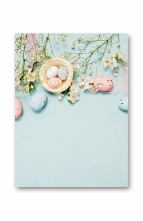 Flat lay of Easter eggs, decorative nests, and blue feathers on pastel blue background, greeting card concept with festive spring design