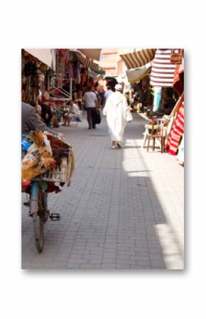 Homme poussant un vélo dans le souk de Marrakech