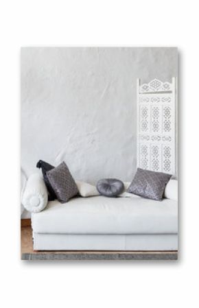 Eastern traditional interior. Morocco style room. Arch and window with beautiful carving. White and gray room with beautiful white sofa and pillows